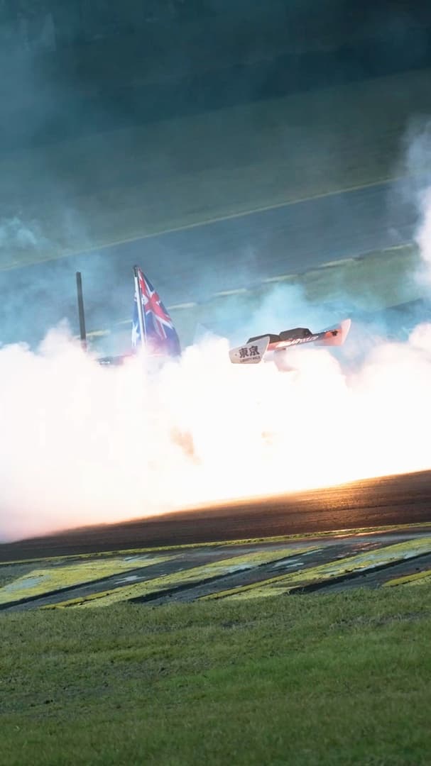 Drift car through tyre smoke, Australian flag flying — track reel